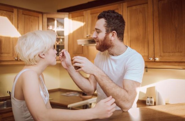 A las mujeres les resulta sexy y divertido que un hombre les cocine. pareja en la cocina