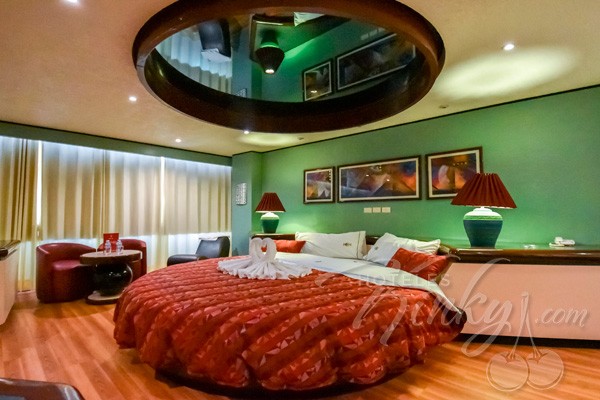 Mima a tus sentidos y disfruta de mirar sus cuerpos fusionados en el reflejo del espejo sobre la cama.