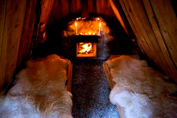 Duerme sobre alfombras de piel de oveja a la luz de las linternas frente a la chimenea.